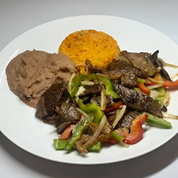 Beef fajitas with colorful bell peppers and onions, served with refried beans and orange rice.